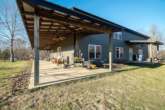 rear view of property with a yard, a patio area, and a ceiling fan