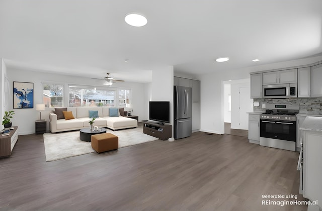 living area with baseboards, wood finished floors, and ceiling fan