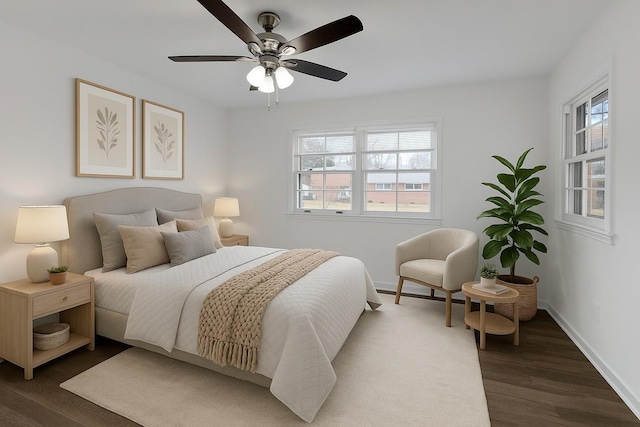 bedroom featuring baseboards, dark wood finished floors, and multiple windows