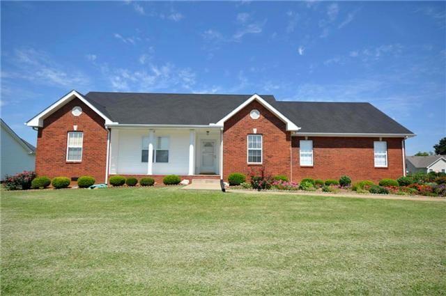 ranch-style home featuring brick siding and a front yard