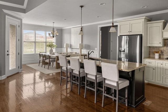 kitchen with crown molding, a sink, dark wood finished floors, and stainless steel fridge with ice dispenser