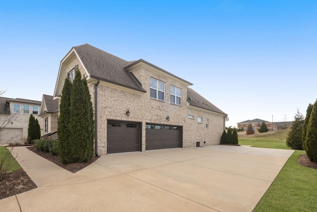 view of side of home with a garage, brick siding, a shingled roof, driveway, and a lawn