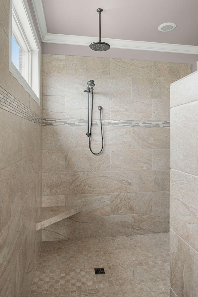 bathroom with a tile shower and crown molding