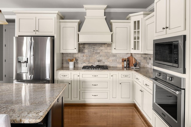 kitchen featuring stainless steel appliances, tasteful backsplash, custom exhaust hood, and crown molding