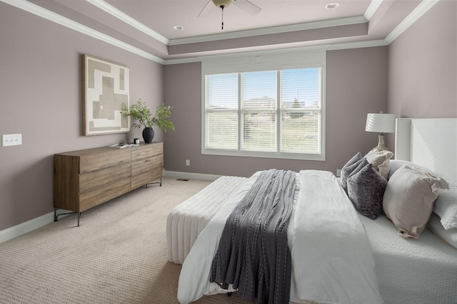 bedroom featuring ornamental molding, a tray ceiling, baseboards, and light colored carpet