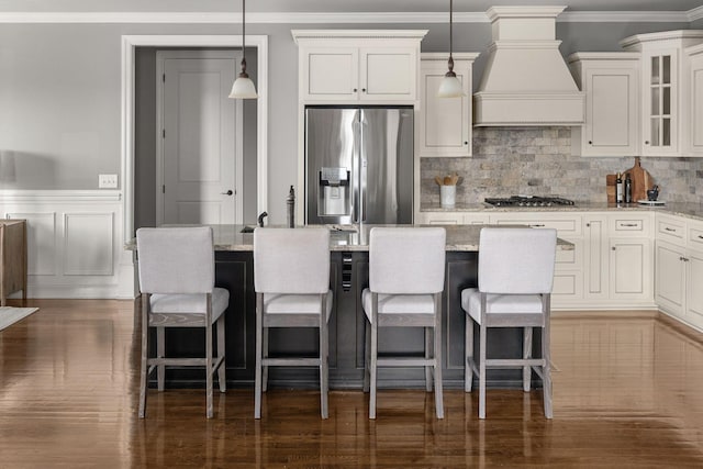 kitchen featuring stainless steel appliances, glass insert cabinets, light stone counters, and custom exhaust hood