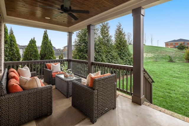 wooden terrace featuring ceiling fan, an outdoor hangout area, and a lawn