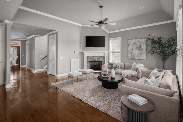 living room featuring lofted ceiling, a stone fireplace, wood finished floors, visible vents, and ornamental molding