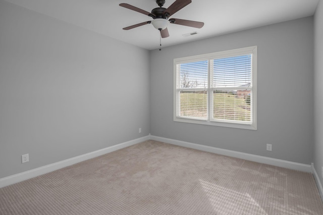 unfurnished room featuring a ceiling fan, light colored carpet, visible vents, and baseboards