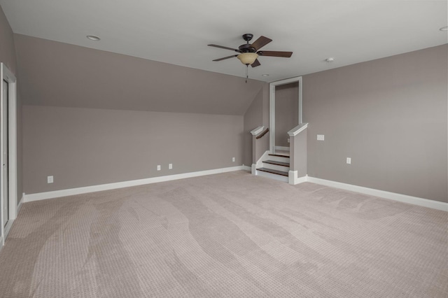 additional living space featuring lofted ceiling, stairway, light carpet, ceiling fan, and baseboards