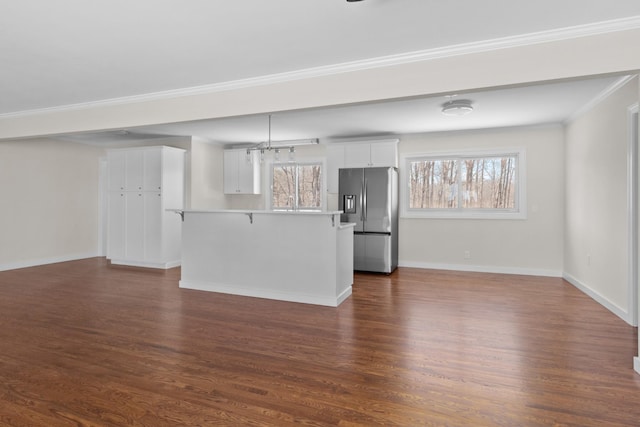 unfurnished living room featuring baseboards, ornamental molding, and dark wood-style flooring