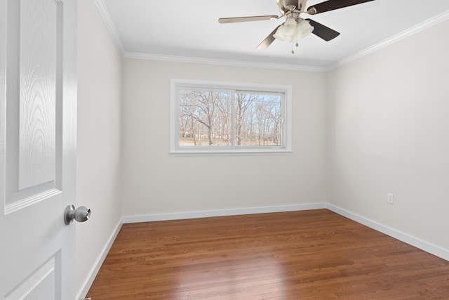 unfurnished room with ornamental molding, wood finished floors, and baseboards