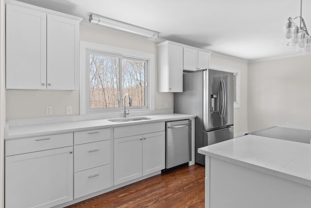 kitchen featuring dark wood finished floors, stainless steel appliances, light countertops, white cabinetry, and a sink