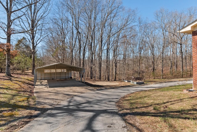 view of property exterior with a carport and aphalt driveway