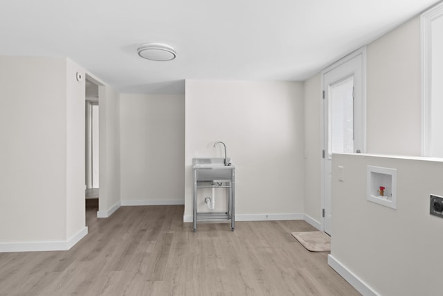 laundry room with hookup for a washing machine, laundry area, a sink, baseboards, and light wood-type flooring