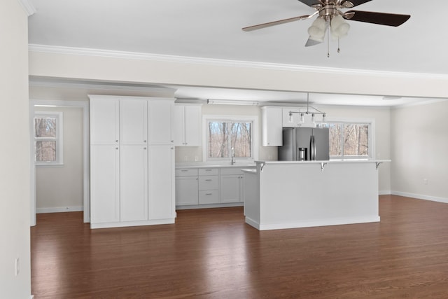 kitchen with dark wood-style floors, stainless steel fridge, white cabinetry, and a center island