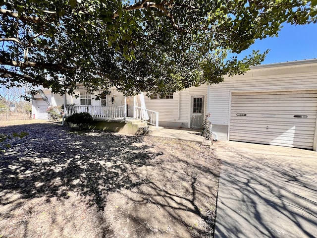 view of front facade with a garage, covered porch, and driveway