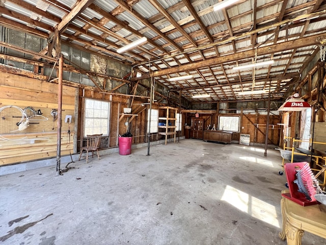 miscellaneous room with a garage, plenty of natural light, and unfinished concrete floors