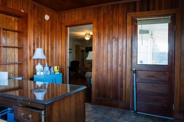 interior space with wood walls and a ceiling fan