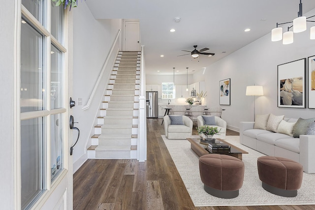 living area with dark wood-style floors, stairway, baseboards, and recessed lighting