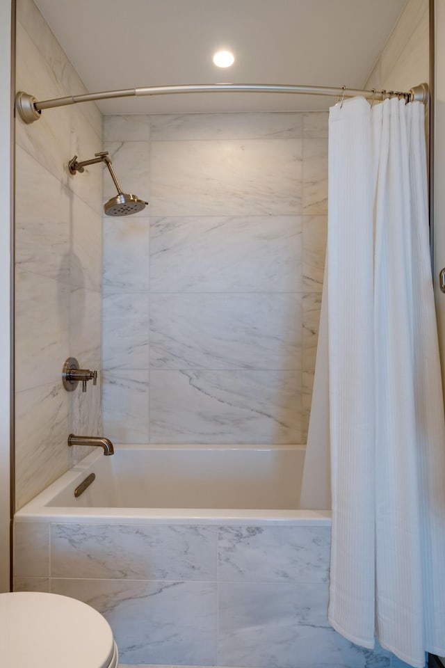 bathroom featuring shower / bath combination with curtain and toilet