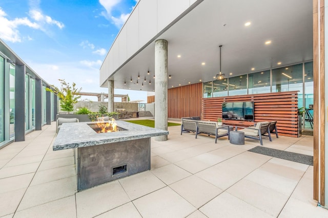 view of patio / terrace with fence and an outdoor living space with a fire pit