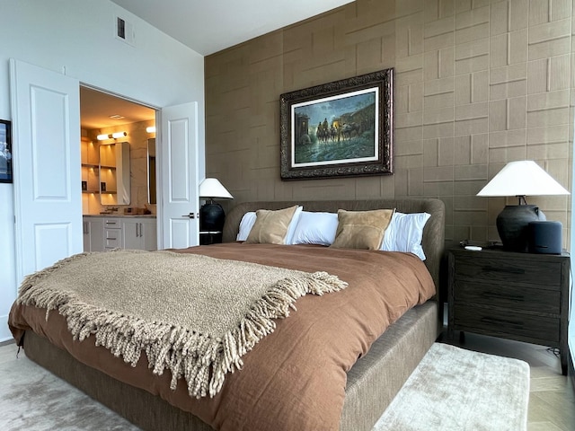 bedroom with visible vents and connected bathroom