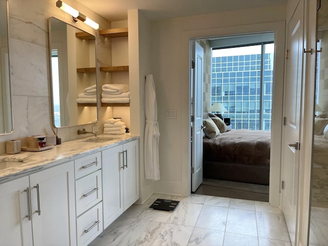 full bathroom featuring connected bathroom, marble finish floor, a sink, and double vanity