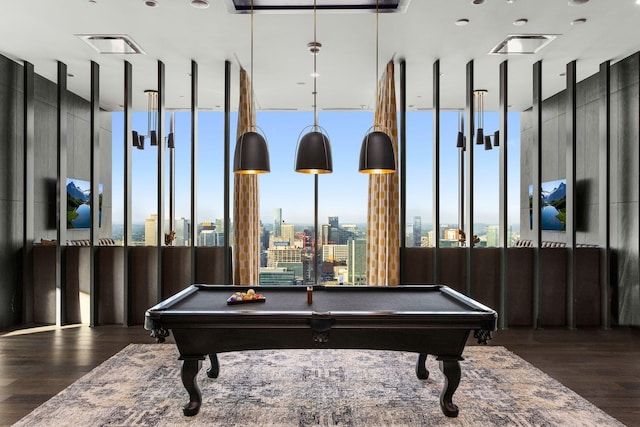 rec room with visible vents, a city view, wood finished floors, and pool table