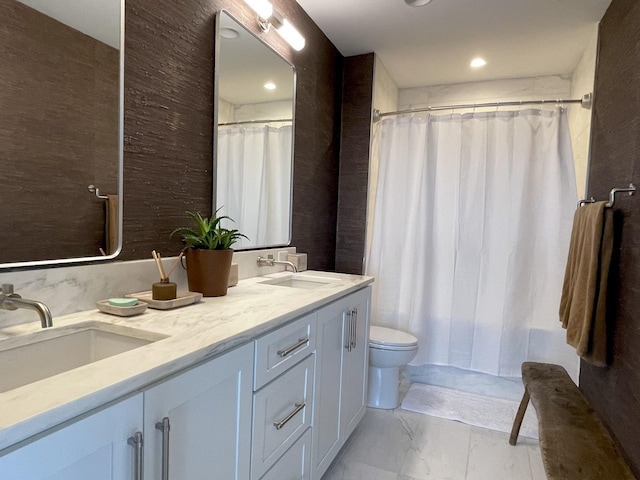 full bathroom featuring marble finish floor, double vanity, a sink, and toilet