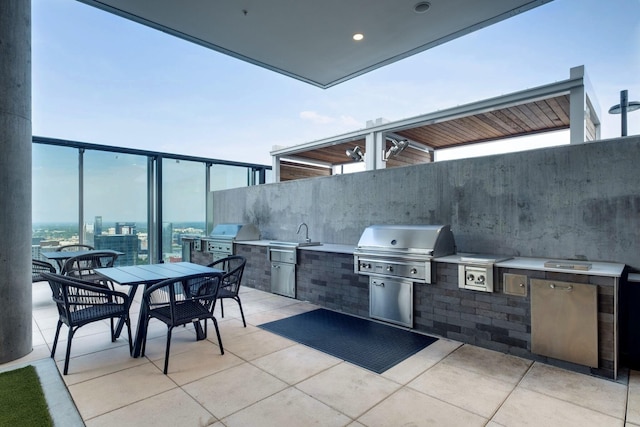 view of patio / terrace with outdoor dining space, a sink, and area for grilling