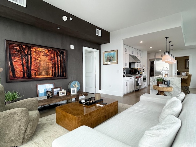 living room featuring recessed lighting, visible vents, and wood finished floors