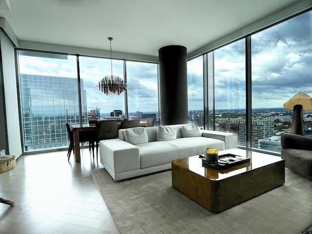 living room featuring a chandelier, a city view, and a wall of windows