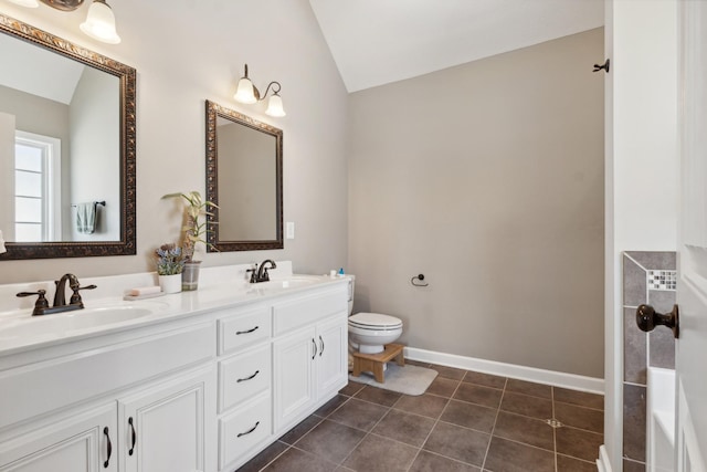 bathroom featuring lofted ceiling, tile patterned flooring, a sink, and toilet