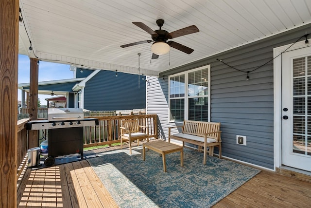 wooden terrace featuring ceiling fan and a grill