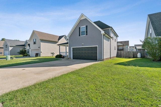 view of side of property with a garage, fence, driveway, a lawn, and a residential view