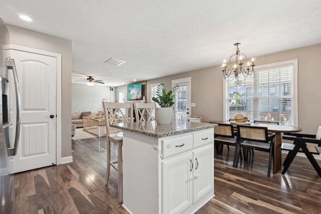 kitchen with dark wood-style floors, decorative light fixtures, white cabinetry, and an inviting chandelier