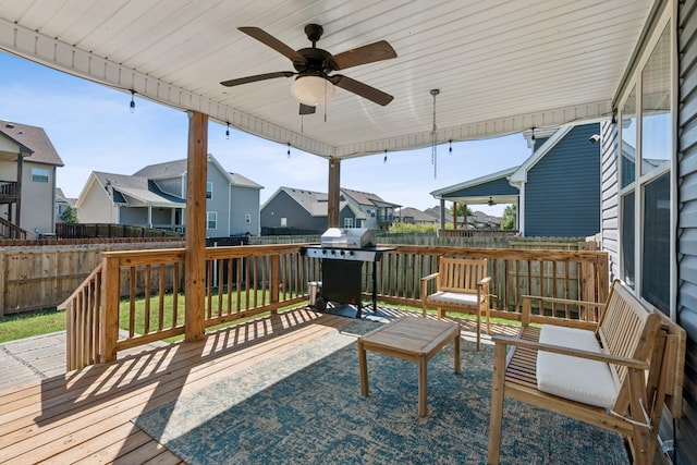 deck featuring a grill, a residential view, fence, and a ceiling fan