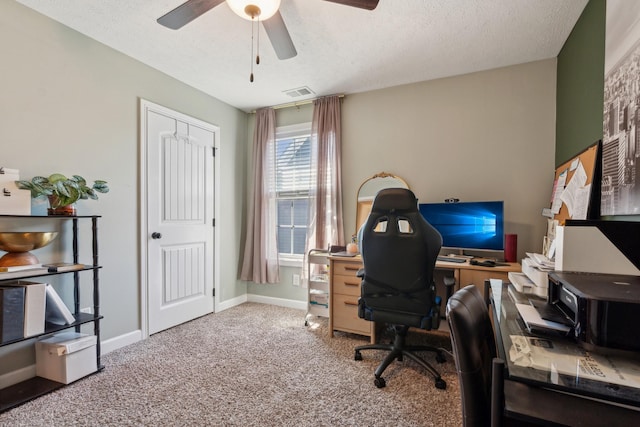 office space with a textured ceiling, carpet flooring, a ceiling fan, visible vents, and baseboards