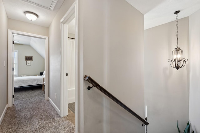 hall with carpet, baseboards, lofted ceiling, and an upstairs landing