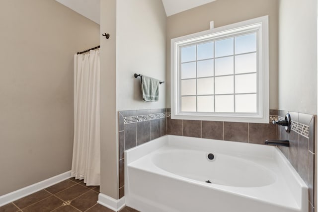 bathroom with a shower with shower curtain, tile patterned flooring, a bath, and baseboards