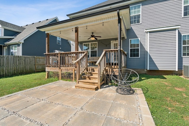 doorway to property with ceiling fan, fence, a yard, a wooden deck, and a patio area