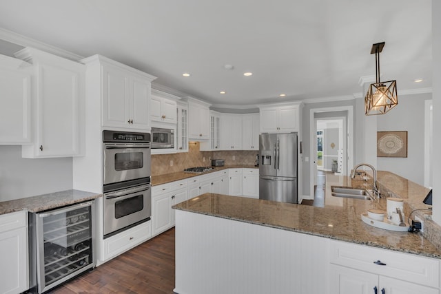 kitchen with wine cooler, stainless steel appliances, crown molding, white cabinetry, and a sink