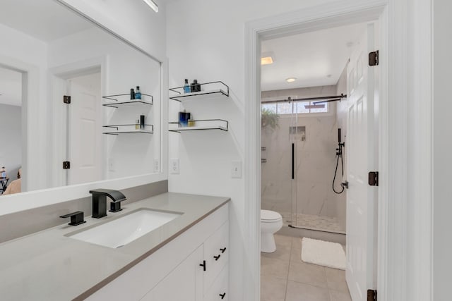 bathroom featuring tile patterned flooring, toilet, vanity, and a marble finish shower