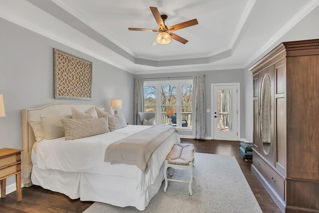 bedroom with access to outside, a raised ceiling, crown molding, and dark wood-style flooring