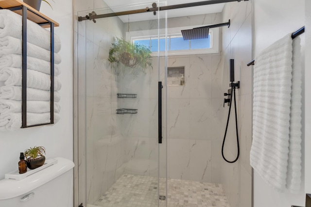 full bathroom featuring toilet and a marble finish shower