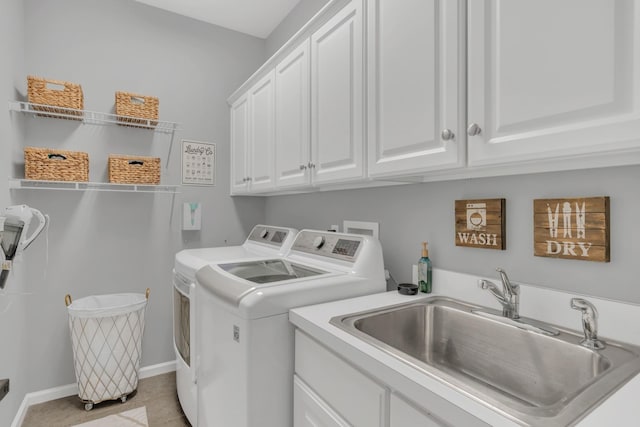 laundry room with light tile patterned floors, a sink, baseboards, independent washer and dryer, and cabinet space