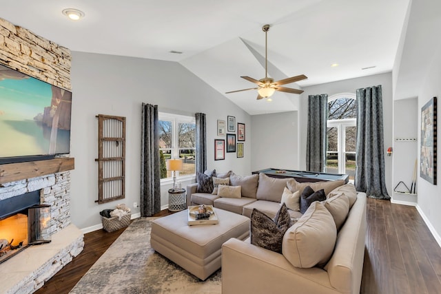 living area with dark wood-style floors, vaulted ceiling, a fireplace, and baseboards