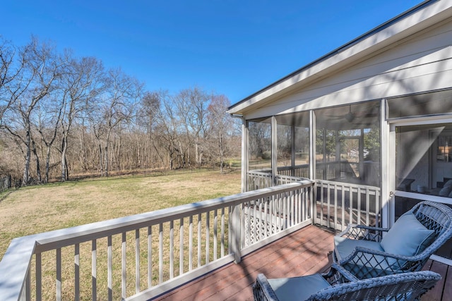 wooden terrace featuring a sunroom and a lawn