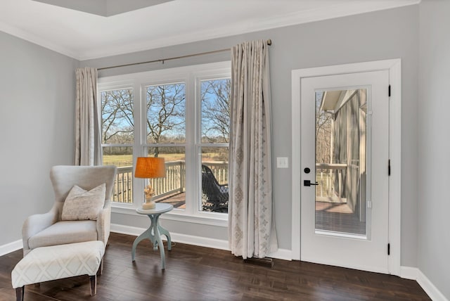 sitting room featuring crown molding, baseboards, and dark wood-type flooring